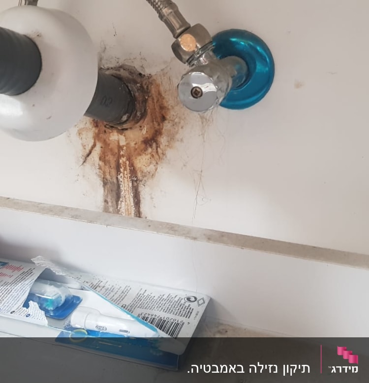 צינור ניקוז מתחת לכיור עם סימני חלודה